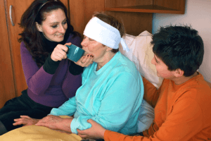 caregiver assisting her patient to drink