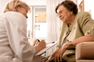 old woman and caregiver setting on the couch